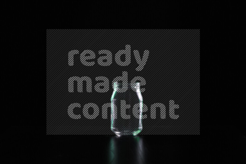 Glassware with rim light in green and white against black background