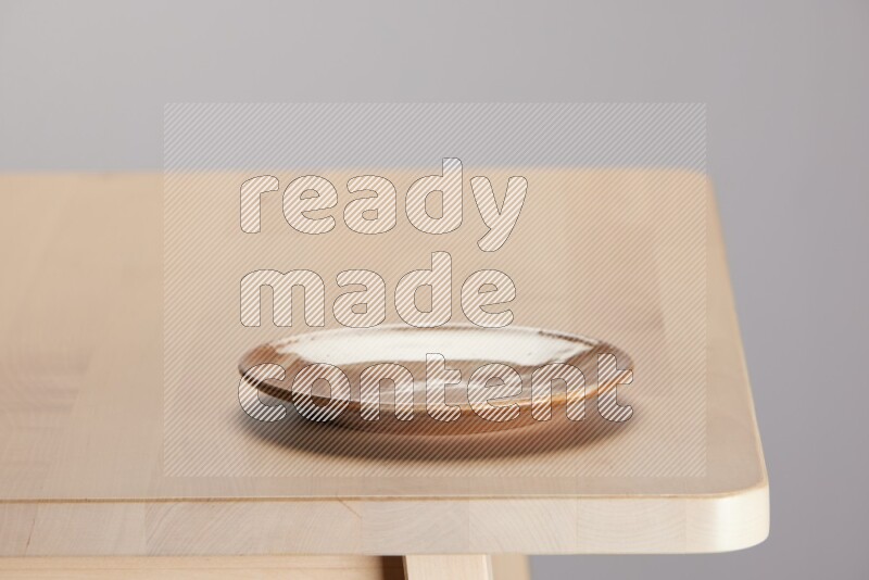 multi-colored pottery Plate on a wooden table edge
