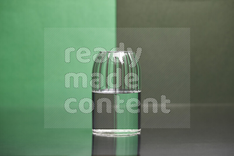 The image features a clear glassware filled with water, set against green and dark green background