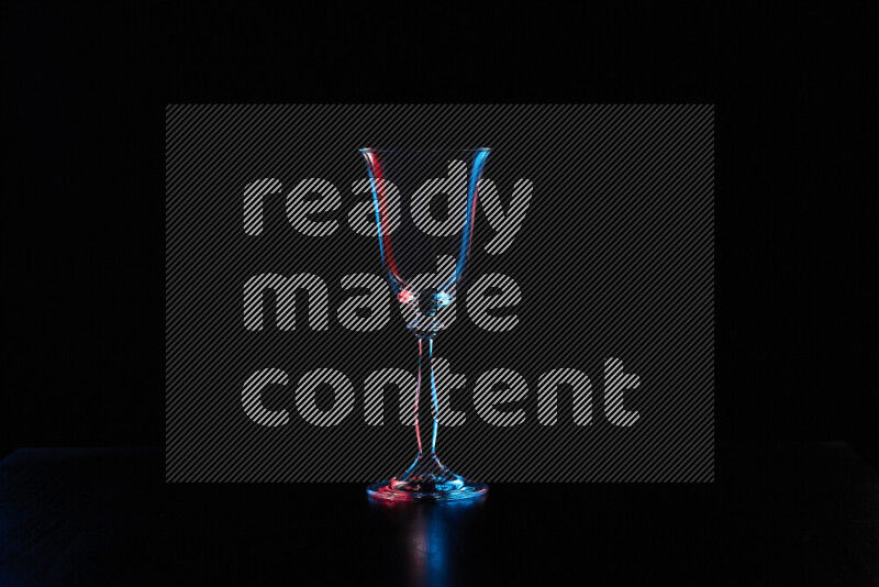 Glassware with rim light in red and blue against black background