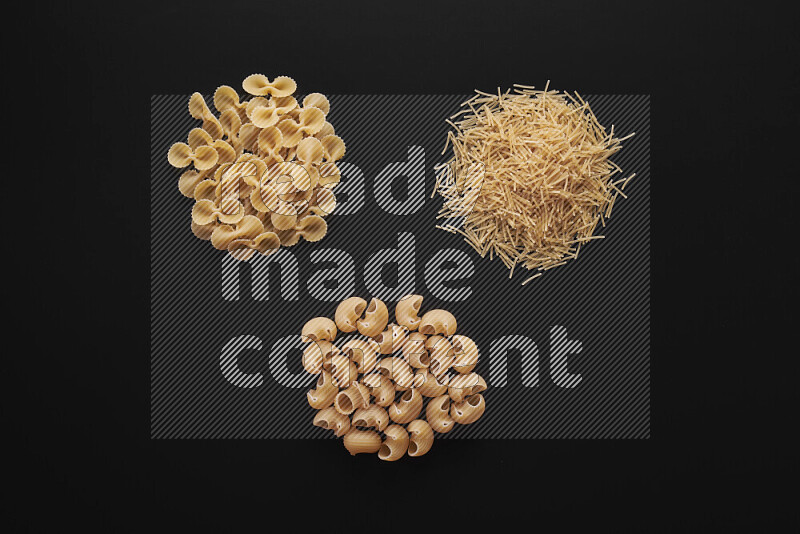 Different pasta types in bunches on black background