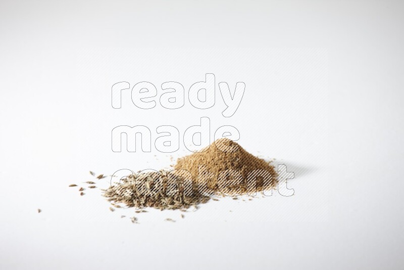 Cumin seeds and cumin powder on white flooring
