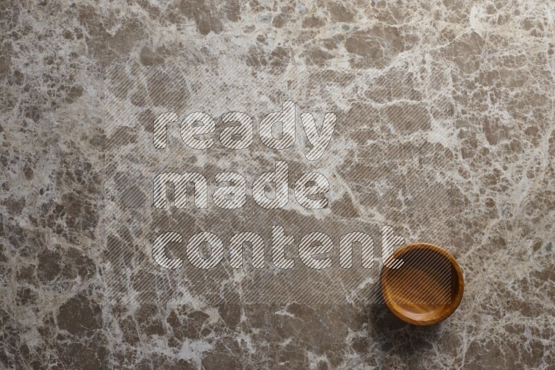 A wooden bowl on beige marble background