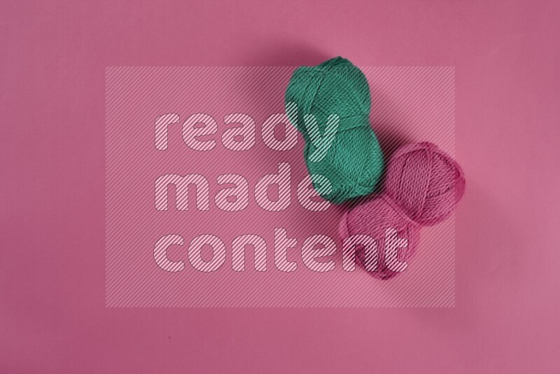 مجموعة من أدوات الخياطة والتفصيل خضراء وزهرية اللون على خلفية زهرية