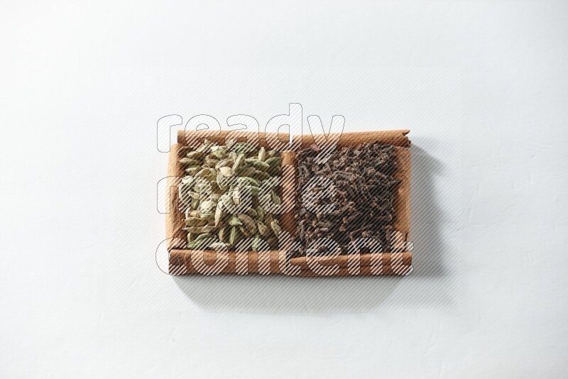 2 squares of cinnamon sticks full of cloves and cardamom on white flooring