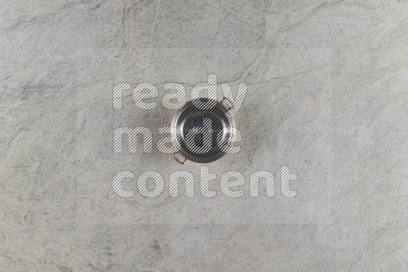 A small copper pot on grey marble background