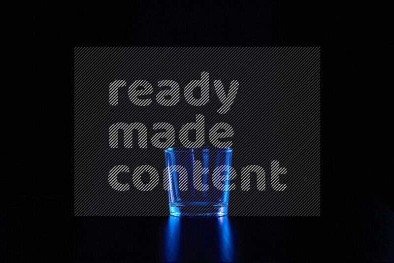 Glassware with rim light in blue against black background