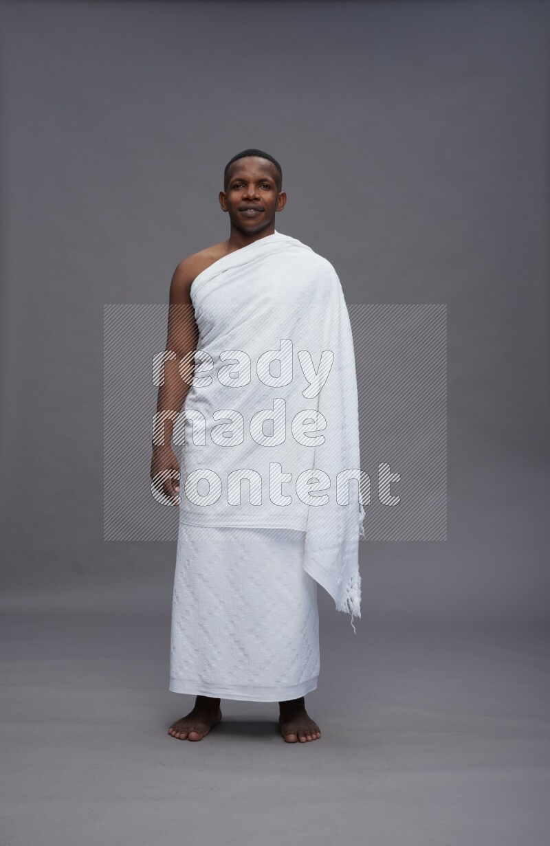 A man wearing Ehram Standing Interacting with the camera on gray background