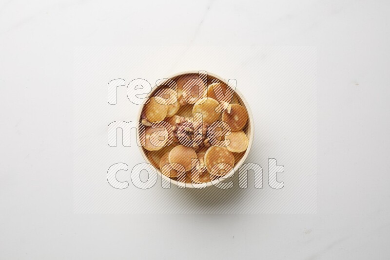 Top-view shot of walnut cereal pancakes in a round bowl on white background