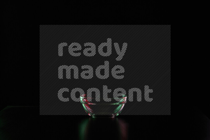 Glassware with rim light in red and green against black background