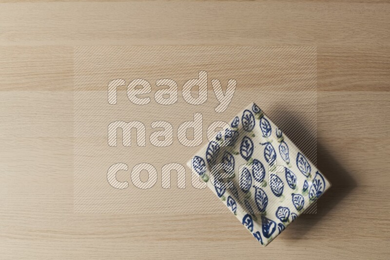 صحن فخاري مزخرف على خلفية خشبية فاتحة