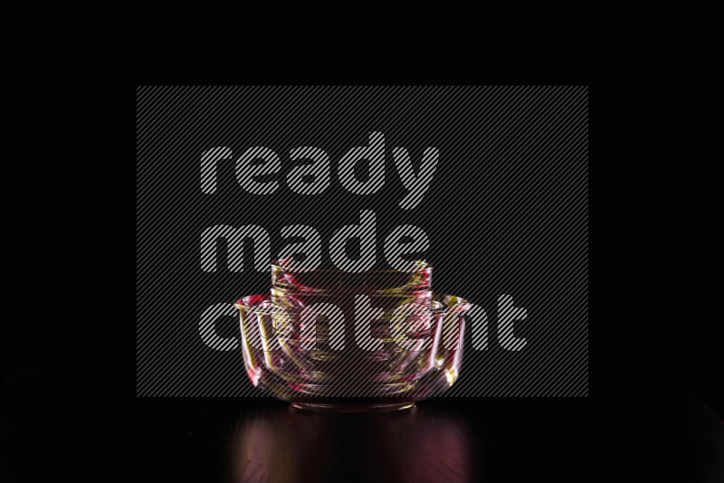 Glassware with rim light in red and yellow against black background