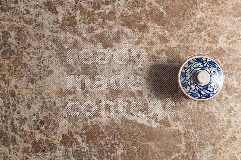 إناء فخاري متعدد الألوان على خلفية من الرخام البيج