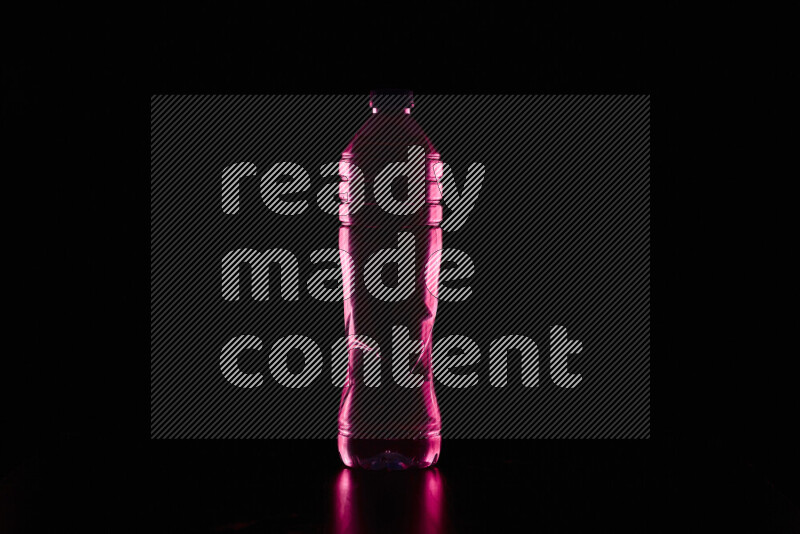 Water bottle with colored rim light against black background