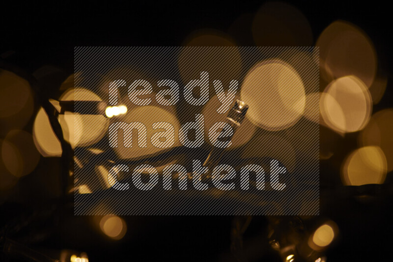 Light bulbs glowing against backdrop of golden bokeh