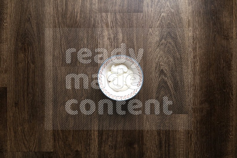 A bowl full of spices and salad dressing ingredients on wooden background