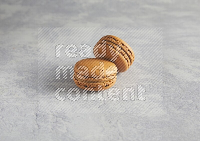 45º Shot of two Brown Maple Taffy macarons  on white  marble background