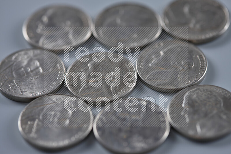 A close-up of scattered United States one dime coins on grey background