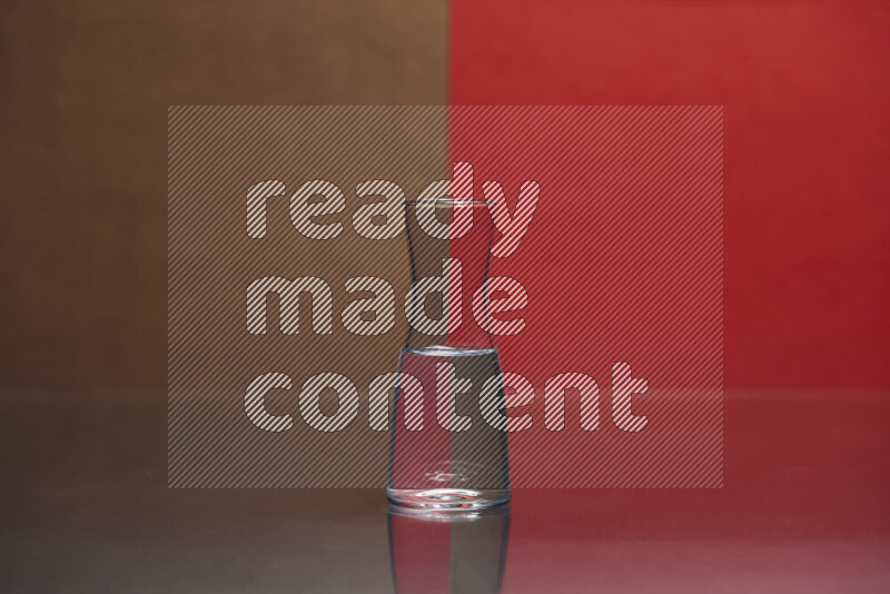 The image features a clear glassware filled with water, set against brown and red background