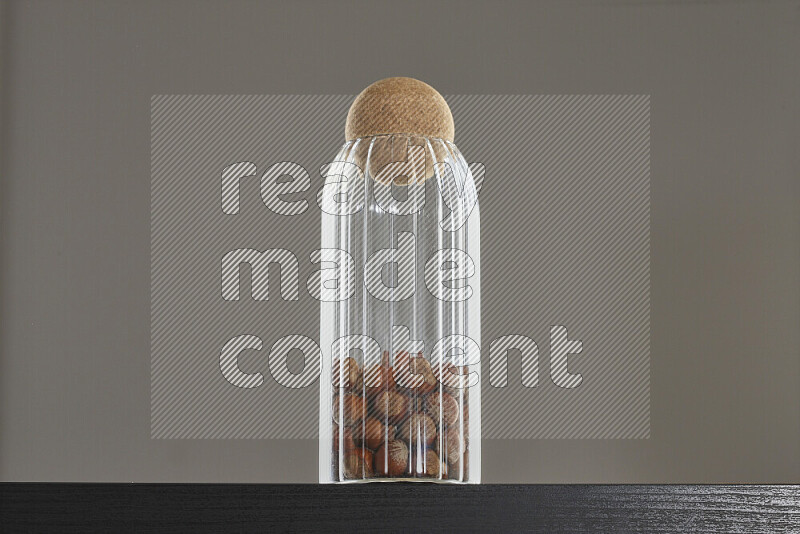 Hazelnuts in a glass jar on black background