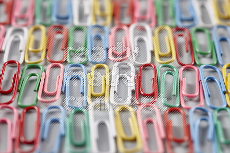 Multicolored paper clips isolated on a grey background