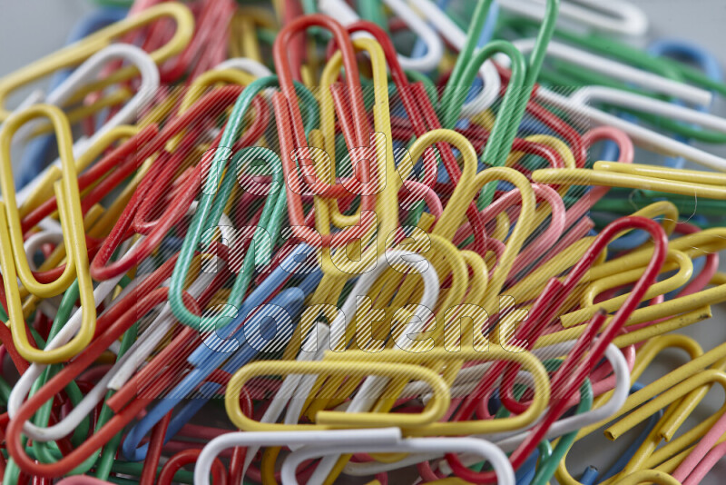 Multicolored paper clips isolated on a grey background