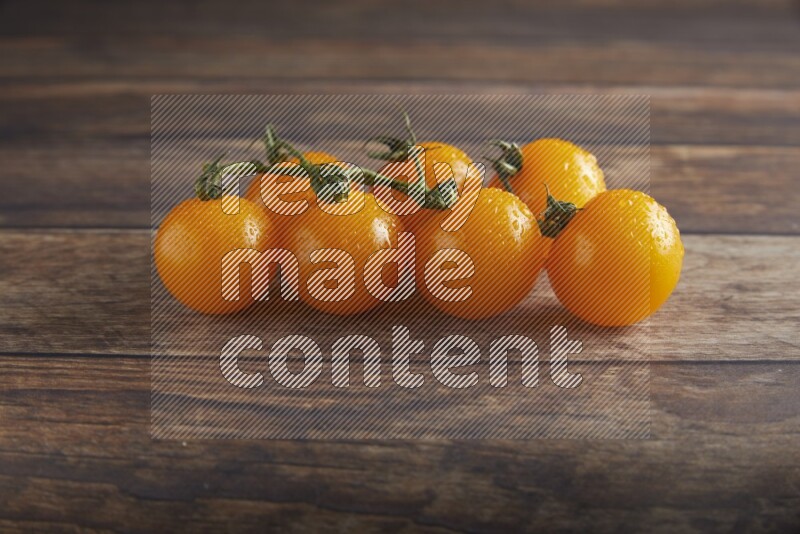 yellow cherry tomato vein on a textured wooden background 45 degree