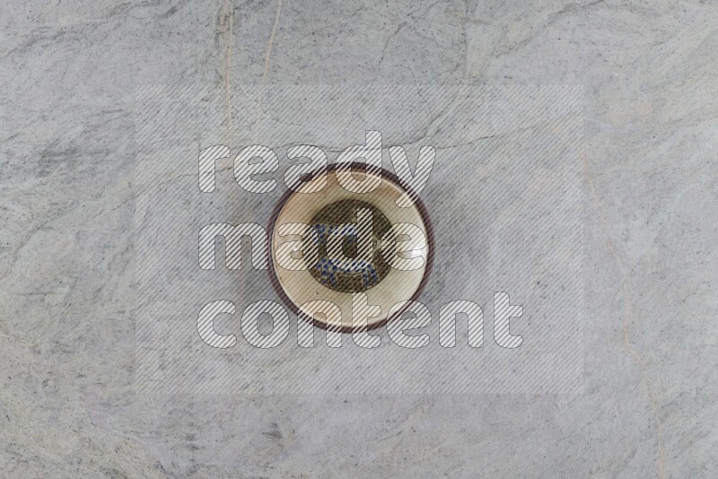A decorative pottery plate on grey marble background