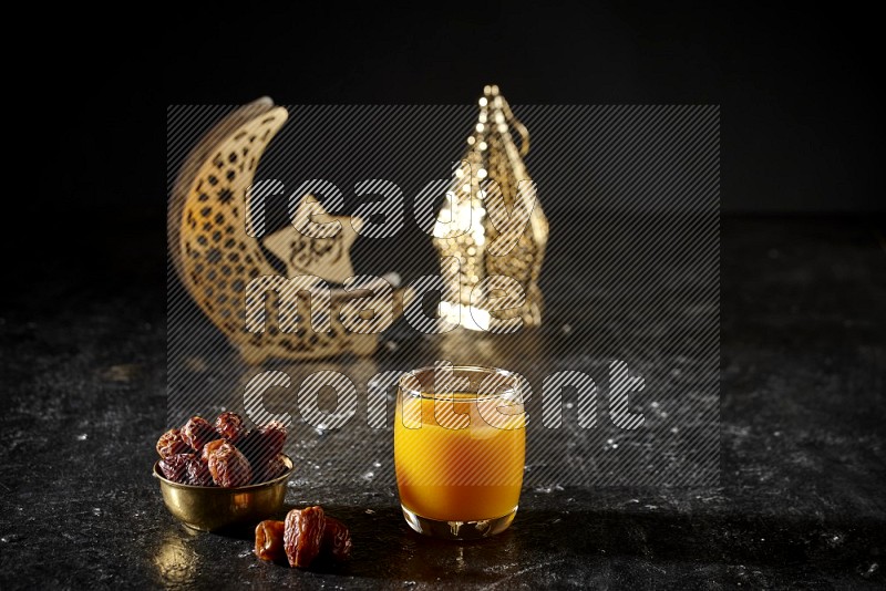 تمر في وعاء معدني مع مشروب قمر الدين بجانب فوانيس ذهبية علي خلفية سوداء