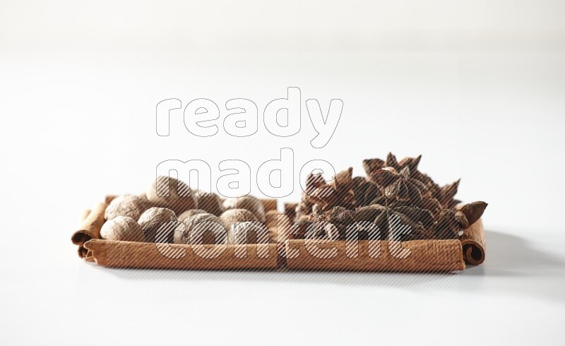 2 squares of cinnamon sticks full of star anise and nutmeg on white flooring