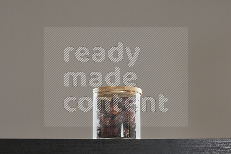 Dates in a glass jar on black background