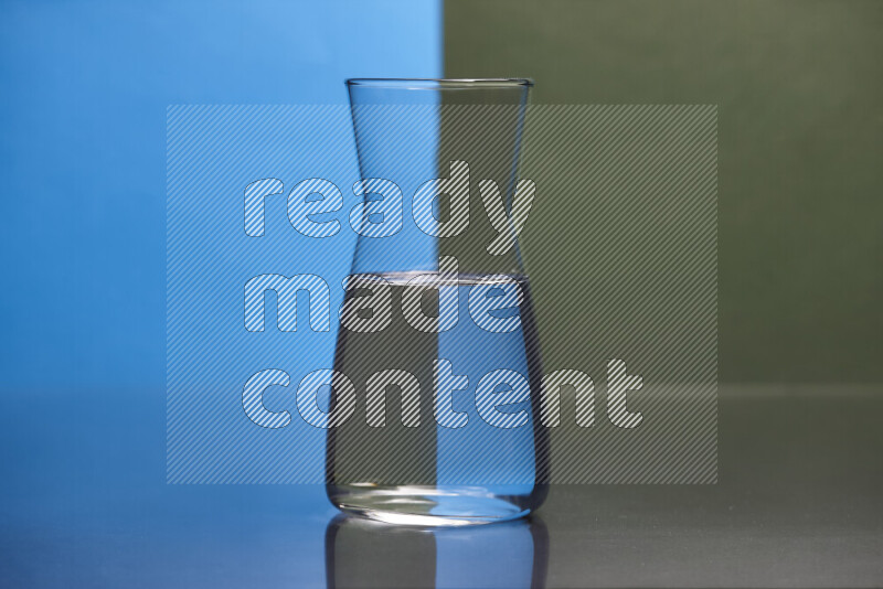 The image features a clear glassware filled with water, set against blue and dark green background