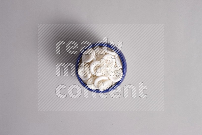 A multicolored pottery bowl full colored buttons on grey background