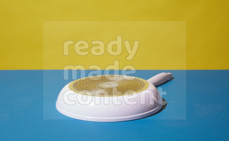 white pan on yellow and Blue background