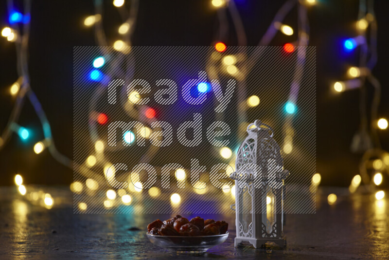 A traditional ramadan lantern surrounded by glowing fairy lights in a dark setup