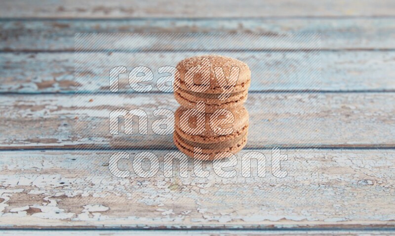 45º Shot of two Brown Hazelnuts macarons on light blue wooden background