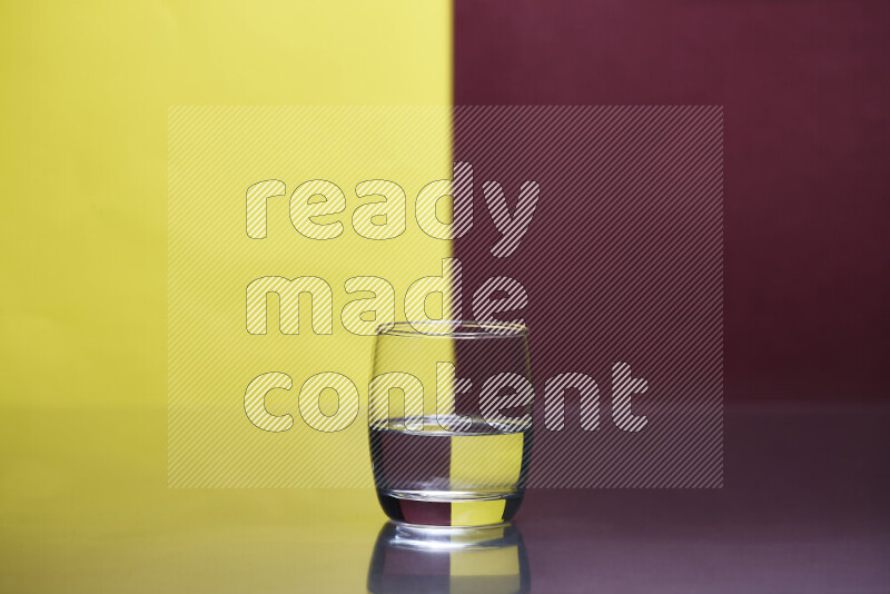 The image features a clear glassware filled with water, set against yellow and dark red background