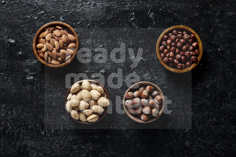 Nuts in wooden bowls in a dark setup
