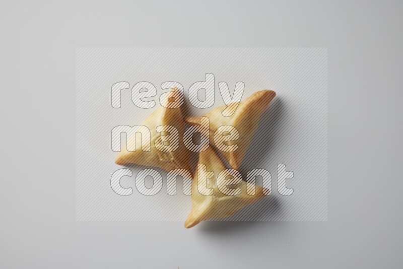 Three fried sambosa from a top angle on a white background
