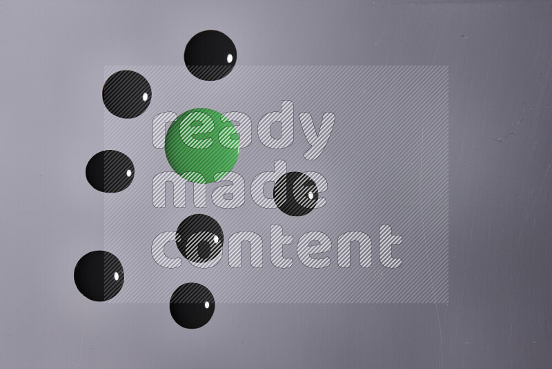 Close-ups of abstract green and black paint droplets on the surface