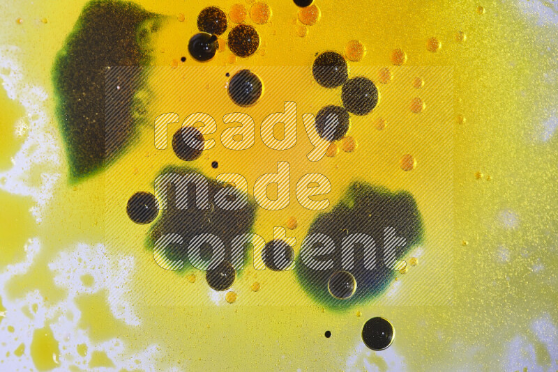 Close-ups of abstract yellow, blue and green watercolor drops on oil Surface on white background