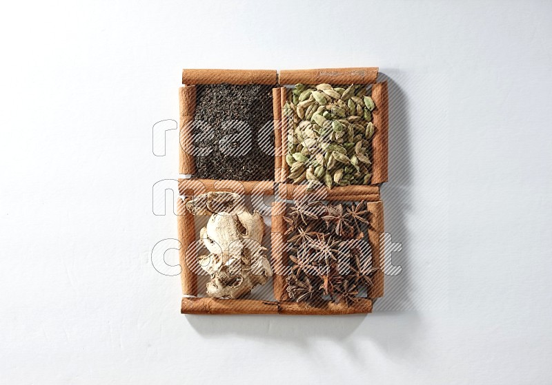 4 squares of cinnamon sticks full of tea, cardamom, star anise and ginger on white flooring