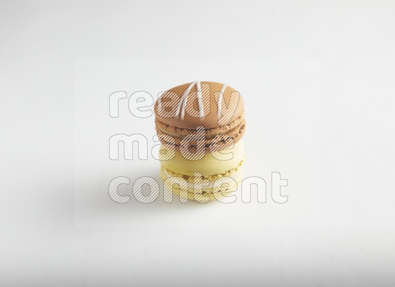 45º Shot of of two assorted Brown Irish Cream, and Yellow Lime macarons on white background