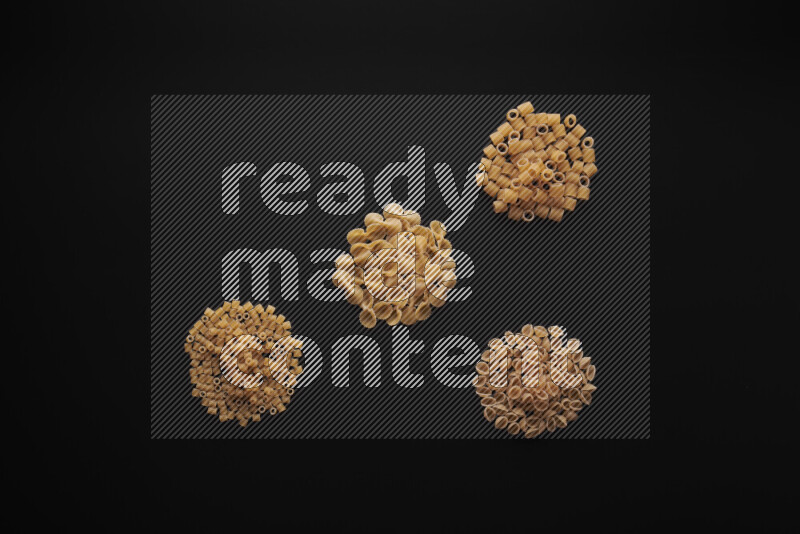 Different pasta types in bunches on black background