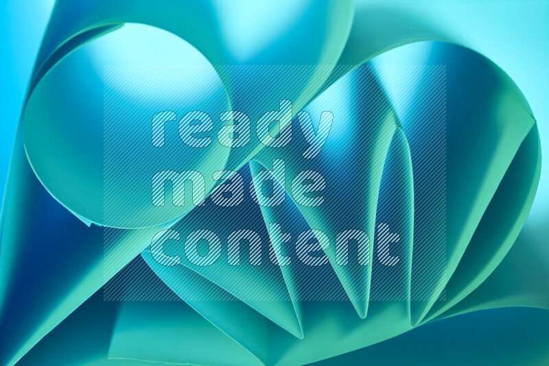 عرض فني لطيات الورق تخلق مزيج من الأشكال الهندسية، مضاءة بإضاءة ناعمة بدرجات اللون الأخضر والأزرق