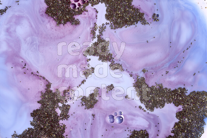 A close-up of sparkling gold glitter scattered on swirling blue and red background