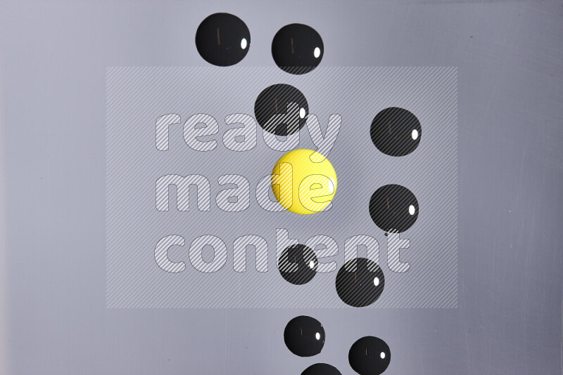 Close-ups of abstract yellow and black paint droplets on the surface