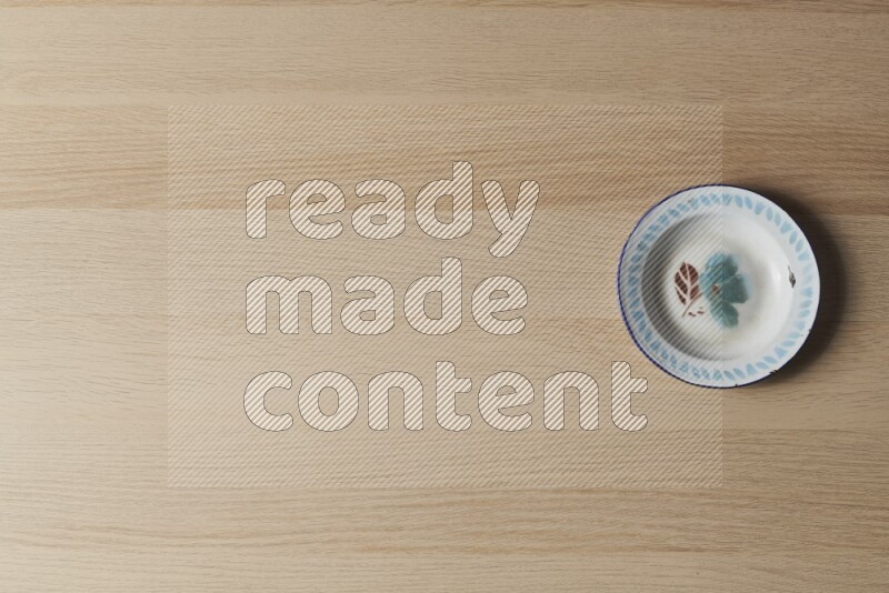 صحن معدني عتيق على خلفية خشبية فاتحة