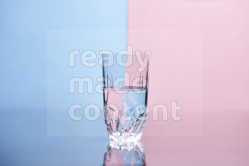 The image features a clear glassware filled with water, set against light blue and rose background