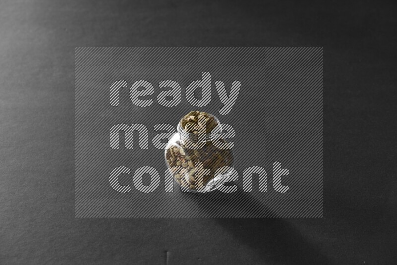 هيل في وعاء زجاجي علي خلفية سوداء